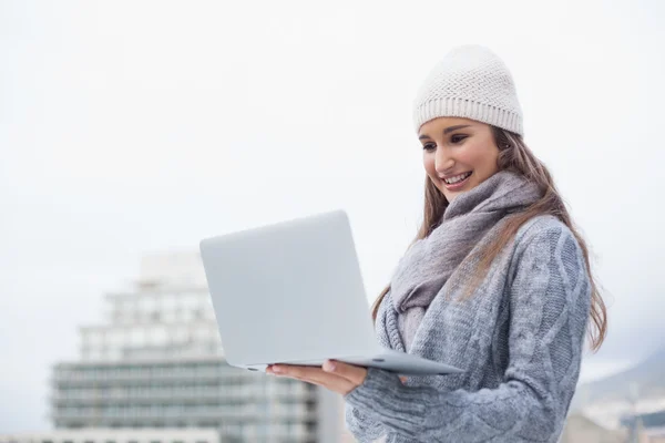 Femme gaie avec des vêtements d'hiver sur l'utilisation de son ordinateur portable — Photo