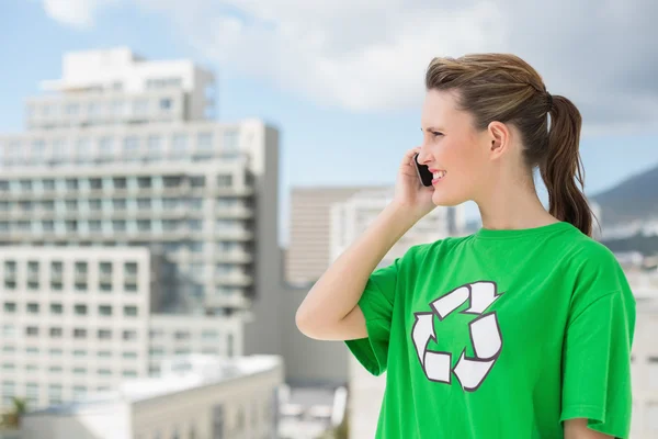 Woman wearing green recycling tshirt talking on the phone — Stock Photo, Image