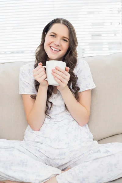 Sorrindo jovem mulher em pijama tendo café — Fotografia de Stock