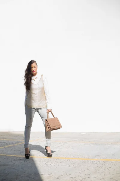 Stylish woman holding brown bag posing — Stock Photo, Image