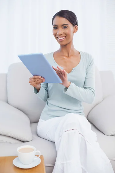 Tablet bilgisayarını kullanarak çekici kadın gülümsüyor — Stok fotoğraf