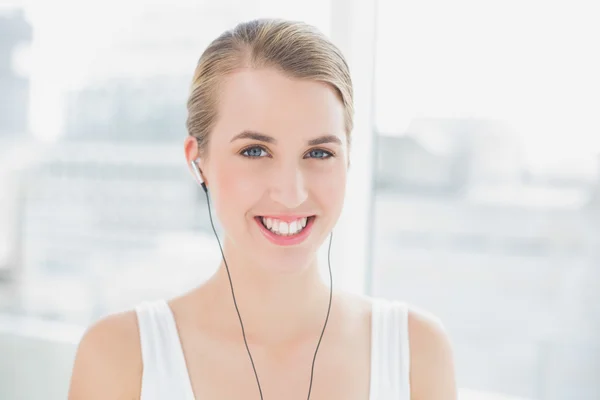 Head shot of cheerful sporty woman listening to music — Stock Photo, Image