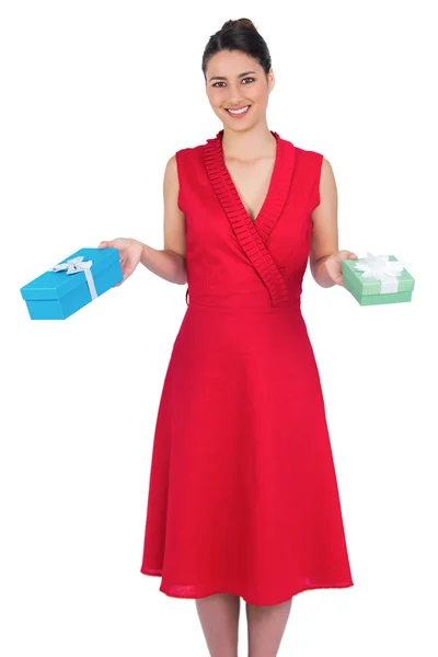 Sorridente modello glamour in abito rosso azienda presenta — Foto Stock