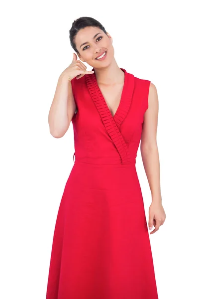 Гламурная модель в красном платье делает телефонный звонок жест — стоковое фото
