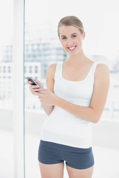 Sorrindo mulher desportiva mensagens de texto — Fotografia de Stock