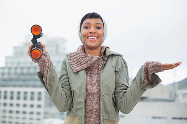 Pleased young model in winter clothes holding binoculars — Stock Photo, Image