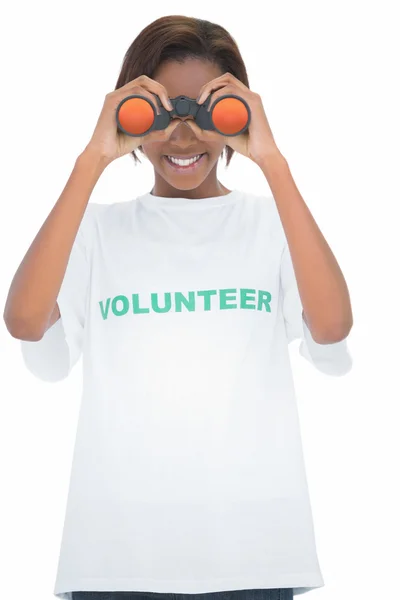 Mulher voluntária alegre olhando através de binóculos — Fotografia de Stock