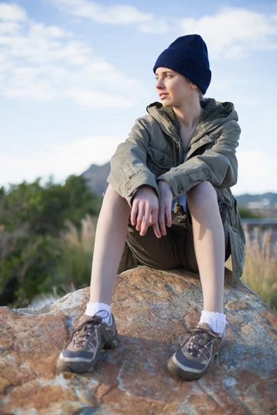 Frau mit Mütze sitzt auf einem Felsen — Stockfoto