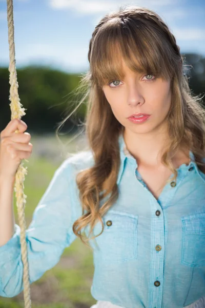 Natürliche junge Frau sitzt auf Schaukel — Stockfoto