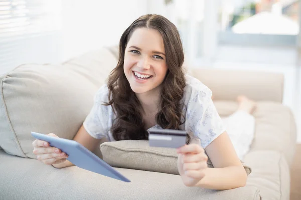 Улыбающаяся женщина использует свою кредитную карту, чтобы купить онлайн — стоковое фото