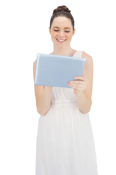 Modelo joven sonriente en vestido blanco usando tableta —  Fotos de Stock