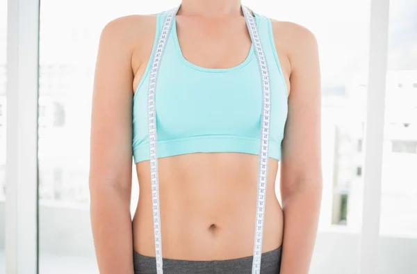 Woman in sportswear holding measuring tape — Stock Photo, Image