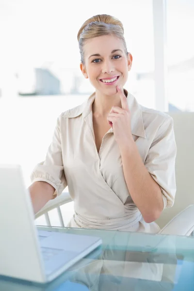 Joyful young blonde businesswoman using a laptop — Stock Photo, Image