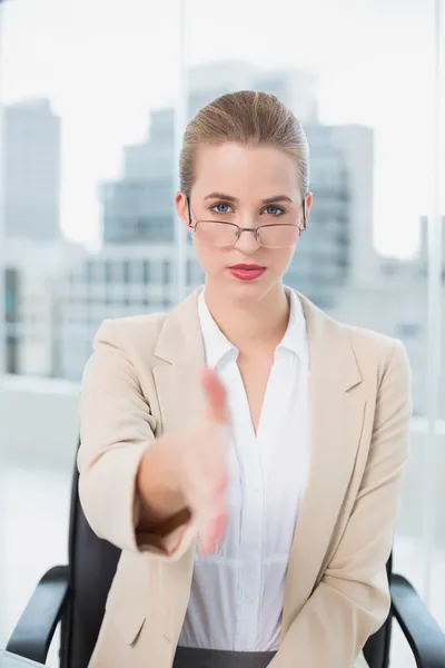 Seriös affärskvinna med glasögon presentera hennes hand — Stockfoto