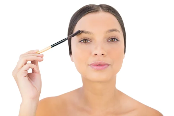 Woman brushing her eyebrow — Stockfoto