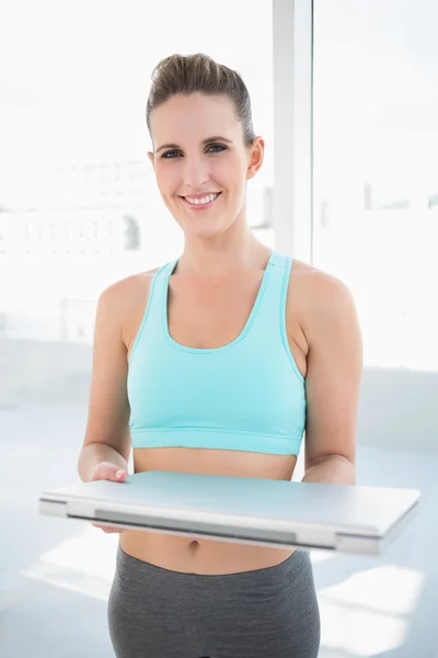 Glad kvinna som bär sportkläder hålla laptop — Stockfoto