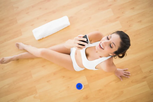 Mutlu bir kadın onun egzersiz sırasında bir metin gönderme uygun — Stok fotoğraf