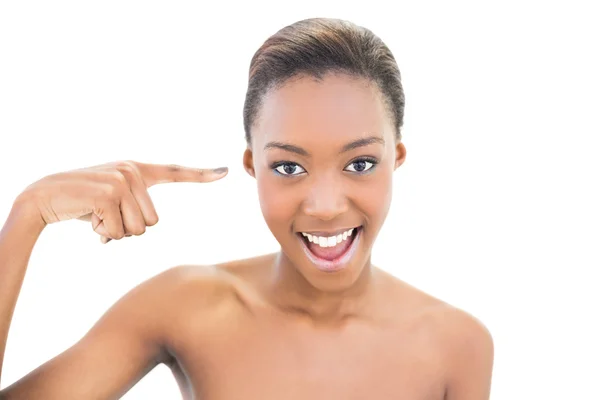 Natural smiling beauty pointing at her temple — Stock Photo, Image