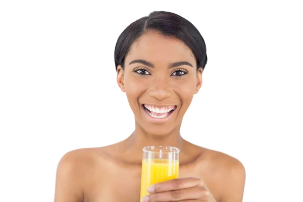 Smiling attractive model holding glass of orange juice — Stock Photo, Image