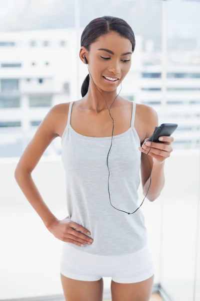 Счастливая привлекательная модель в спортивной одежде слушает музыку — стоковое фото