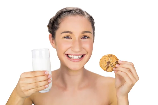 Smiling young model holding cookie and milk — Stock Photo, Image
