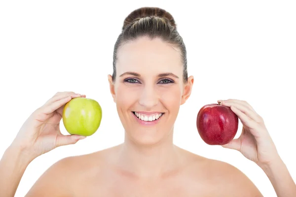 Mulher sorridente segurando maçãs vermelhas e verdes — Fotografia de Stock