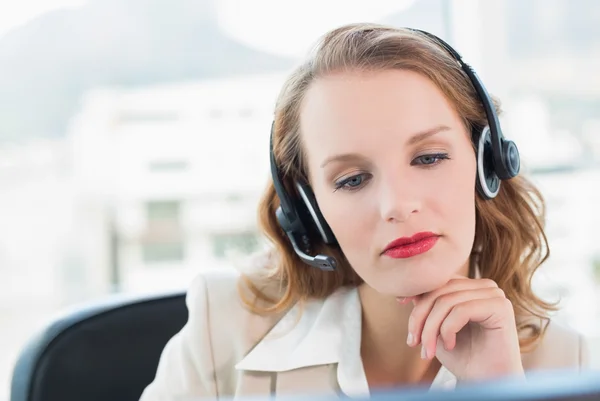 Unsmiling pretty operator looking at her computer — Stock Photo, Image