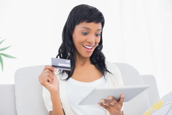 Amazed black haired woman buying online with her tablet pc — Stock Photo, Image