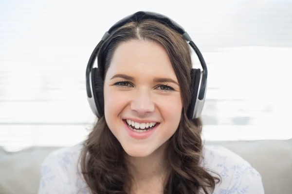Jeune femme souriante qui écoute de la musique — Photo