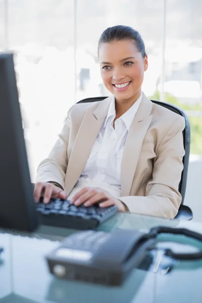 Bilgisayarda çalışan gülümseyen güzel iş kadını — Stok fotoğraf