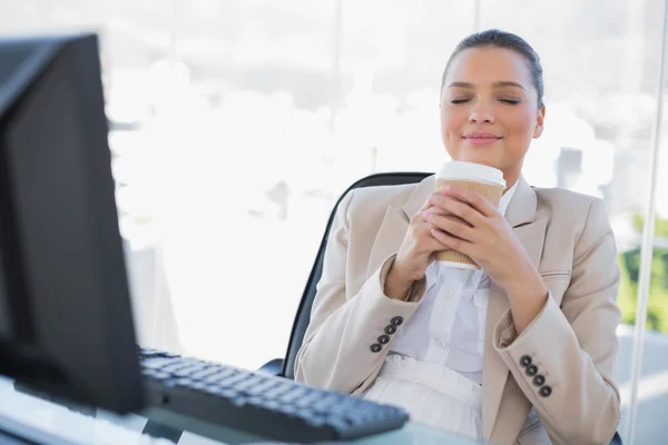 Happy sophisticated businesswoman smelling coffee — Stock Photo, Image