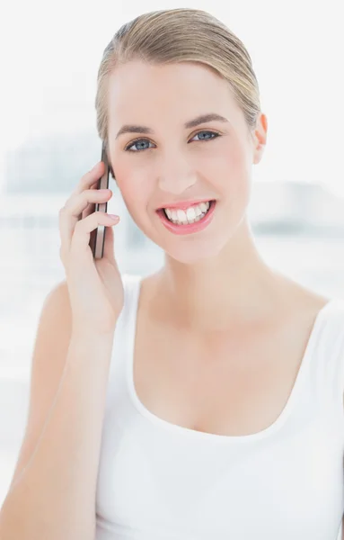 Nahaufnahme einer fröhlichen, sportlichen Frau, die telefoniert — Stockfoto