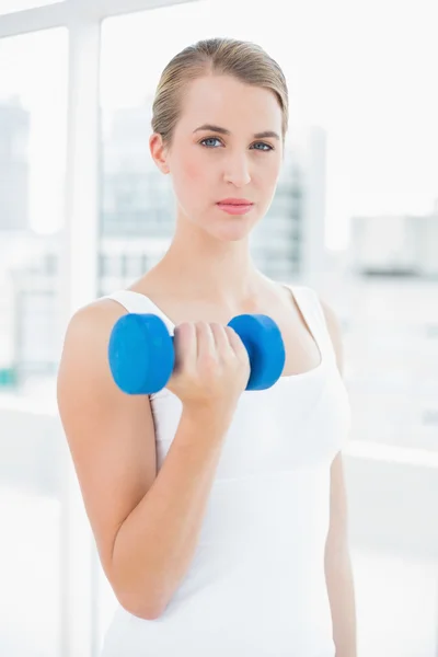 Mujer en forma pensativa haciendo ejercicio con pesas —  Fotos de Stock