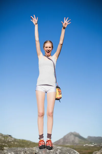 Active woman standing on rock cheering — Stock Photo, Image