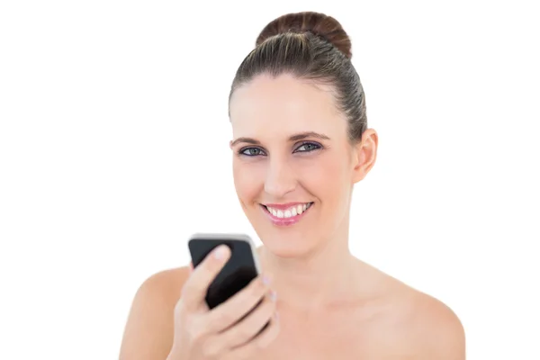 Sorrindo mulher segurando telefone olhando para a câmera — Fotografia de Stock