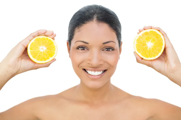 Smiling black haired model holding orange slices — Stock Photo, Image