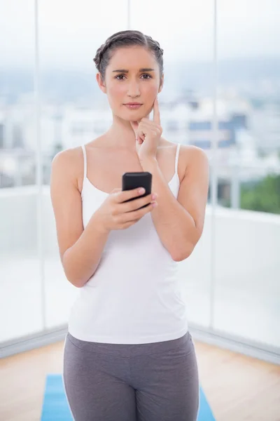 Serious sporty brunette text messaging — Stock Photo, Image