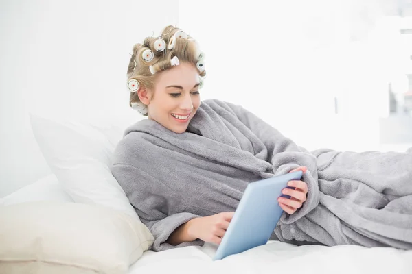 Charmiga avslappnad blonda kvinnan i Hårrullar använder en TabletPC — Stockfoto