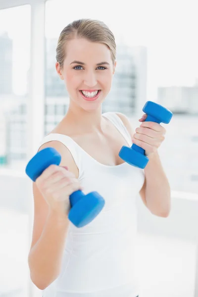 Esportivo sorrindo mulher exercitando-se com halteres — Fotografia de Stock