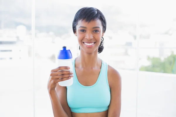 Kobieta trzyma butelkę wody sprawny szczęśliwy — Zdjęcie stockowe