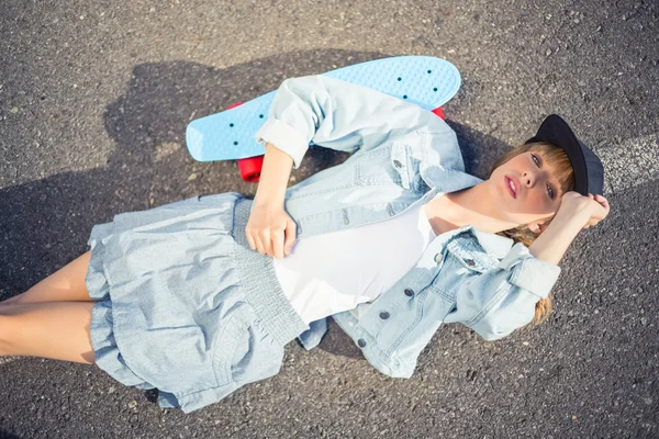 Rebellious blonde skater lying on the road — Stock Photo, Image