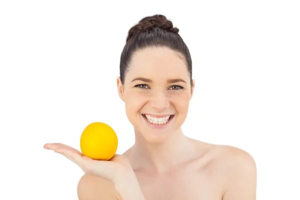 Sorrindo modelo bonito segurando laranja — Fotografia de Stock