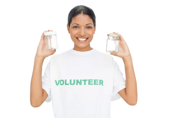 Modelo sorridente vestindo tshirt voluntária segurando panelas — Fotografia de Stock