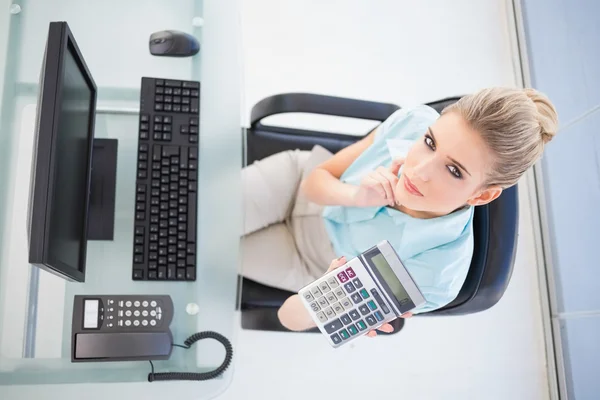 Vue aérienne de femme d'affaires réfléchie montrant la calculatrice — Photo