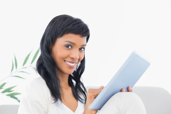 Piacevole donna dai capelli neri in vestiti bianchi digitando su un tablet pc — Foto Stock