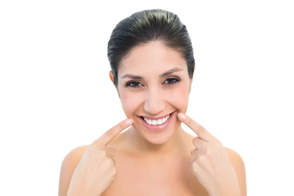 Brunette pointing to mouth and smiling at camera — Stock Photo, Image