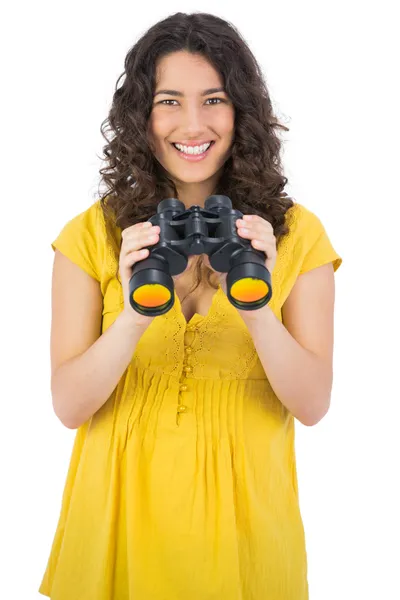 Cheerful casual young woman using binoculars — Stock Photo, Image