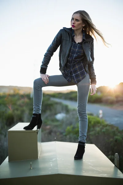 Stylish woman posing on top of a construction — Stock Photo, Image