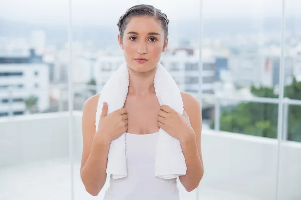 Relajada morena deportiva sosteniendo toalla blanca — Foto de Stock