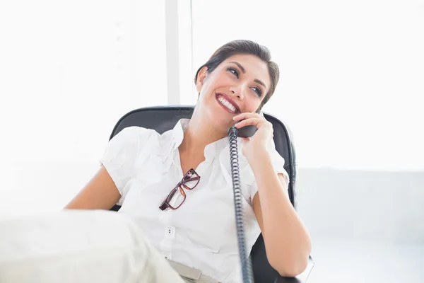 Liggende zakenvrouw zit op haar Bureau praten over telefoon — Stockfoto